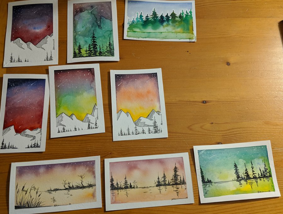 A dozen hand-painted watercolor greeting cards of mountains, forests and northern skies, by Ayesa Kaur