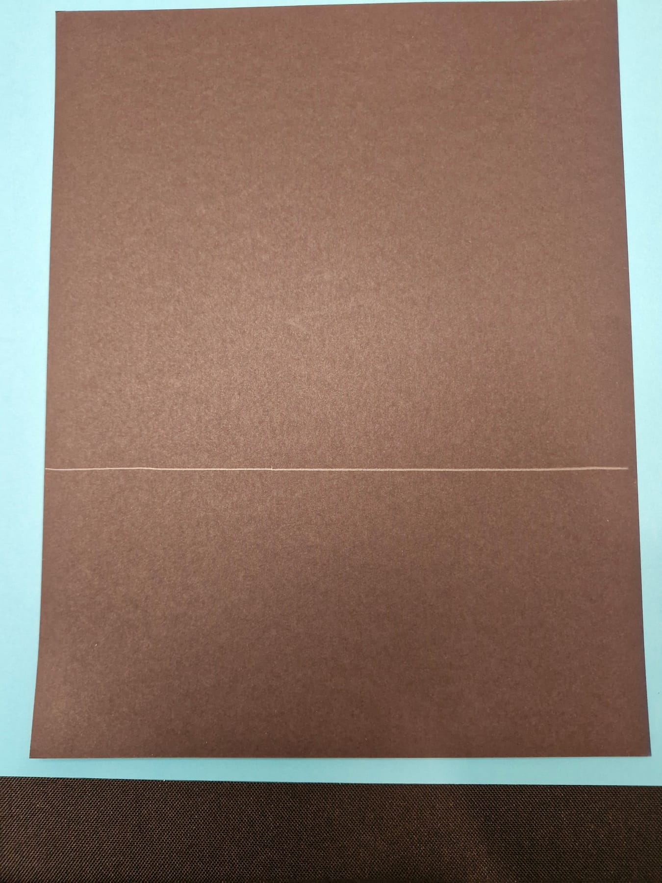 A sheet of black paper with a single pencil line drawn low across it, marking where the land stops and the sky begins.