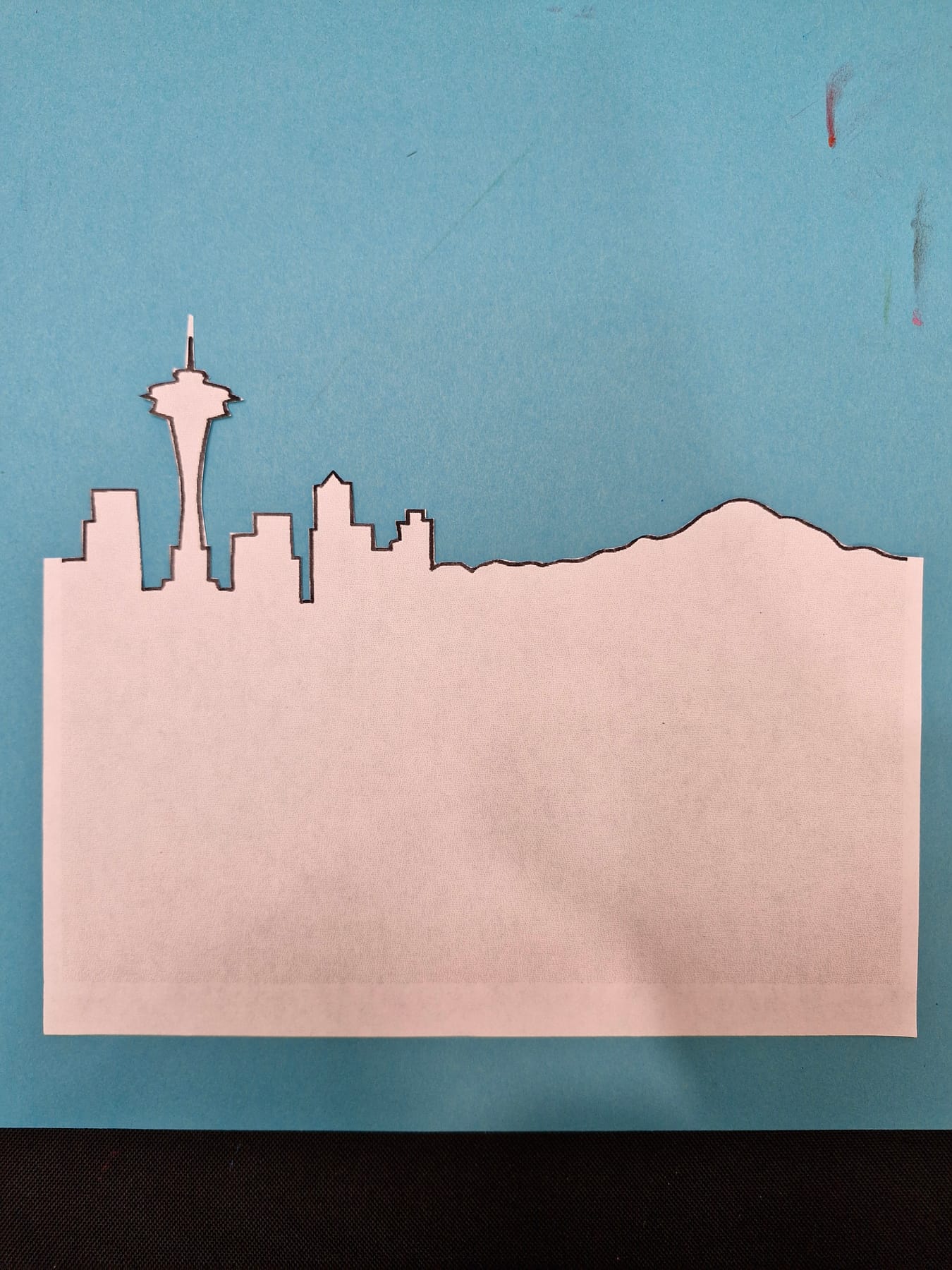 The printed Seattle skyline cut out as one long strip, the Space Needle and the buildings still joined in a row.