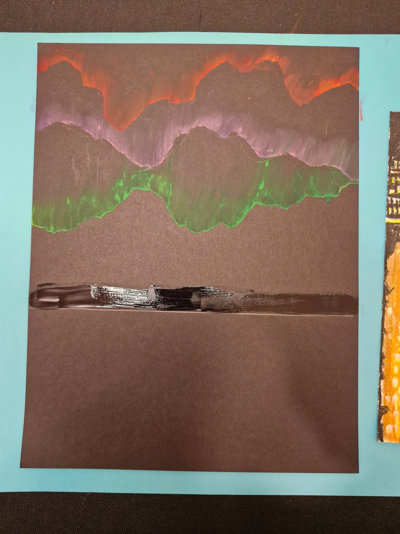 Glue spread in a line along the horizon before the skyline is pressed down onto it.