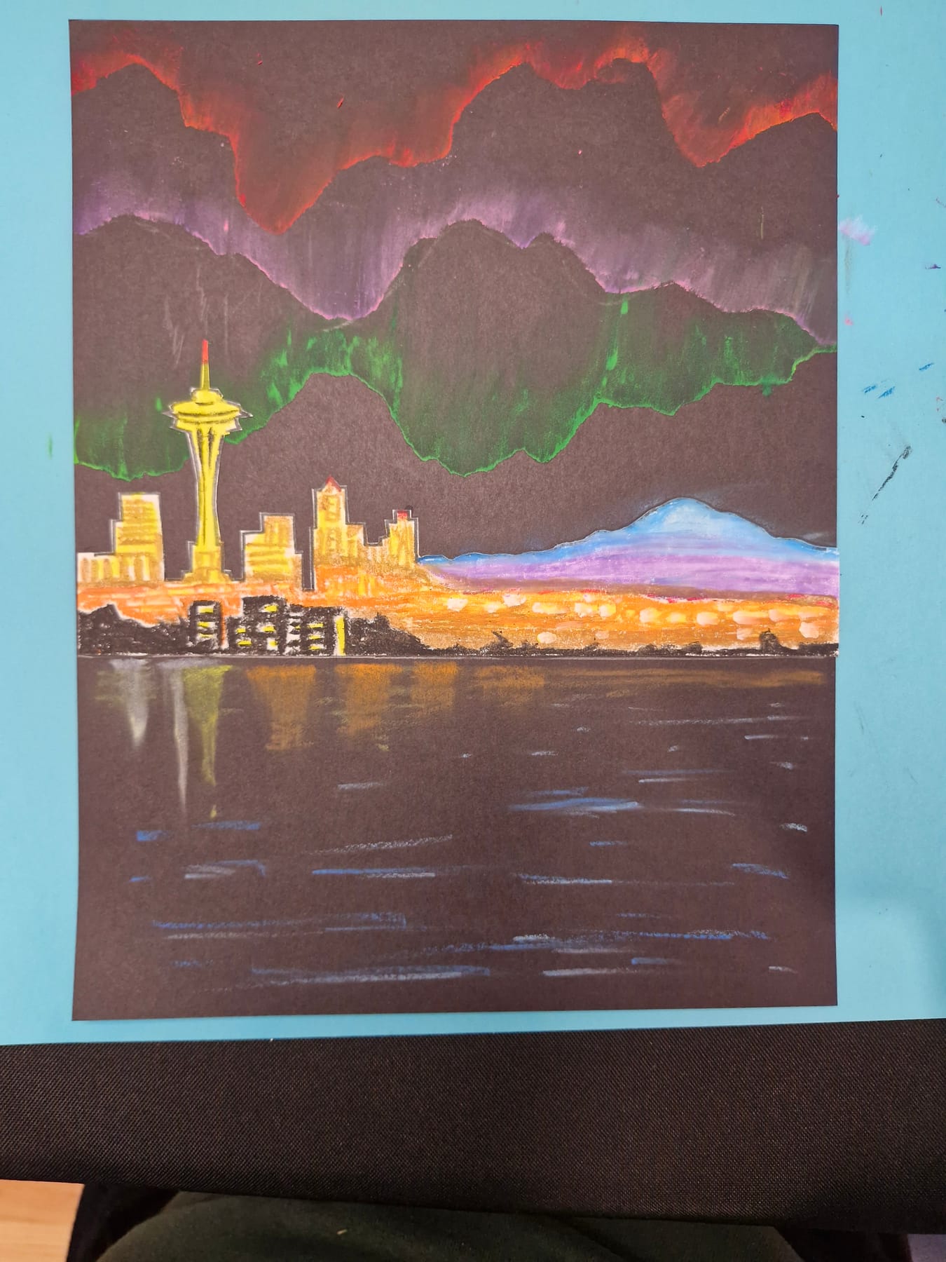 The water finished, long streaks of gold and white reflecting the city across it.